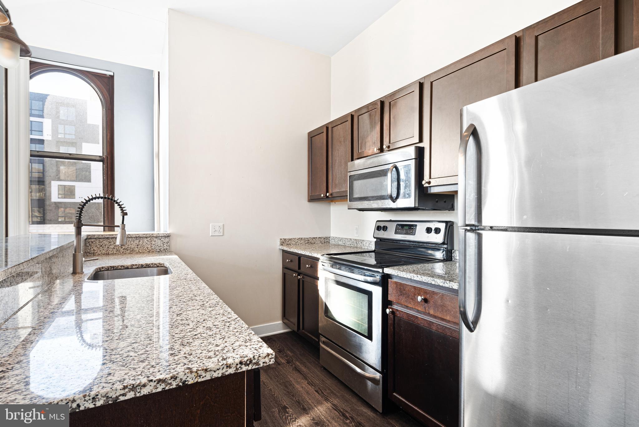 523 North Broad Street, Unit P1 Philadelphia, PA 19123 - Photo 6 of 37 a kitchen with granite countertop a refrigerator stove and sink