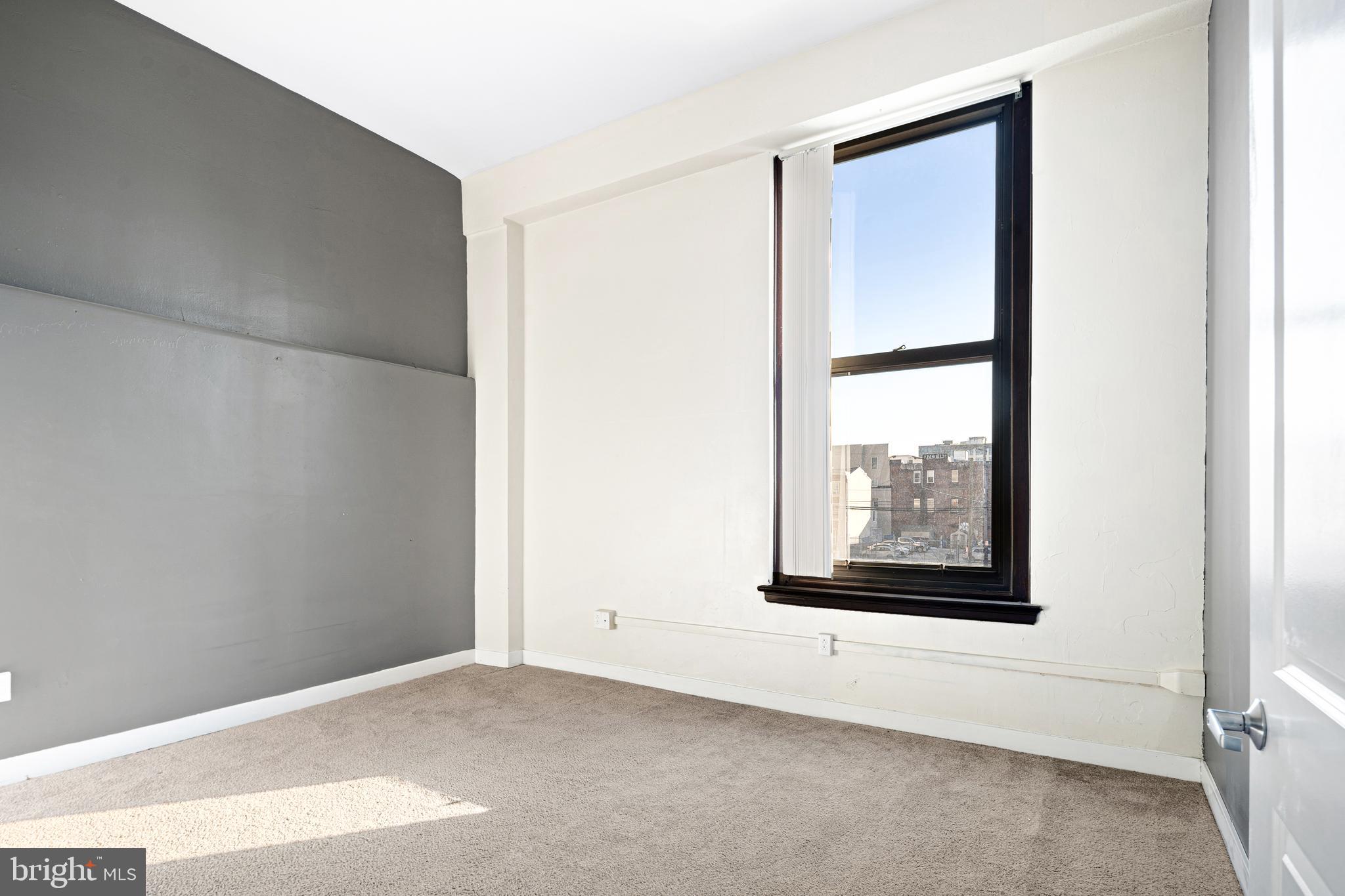 523 North Broad Street, Unit P1 Philadelphia, PA 19123 - Photo 9 of 37 a view of an empty room with wooden floor and a window