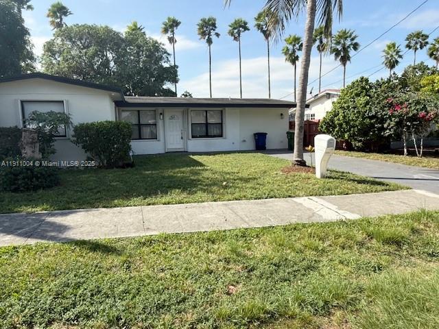 a view of a house with a yard and palm trees