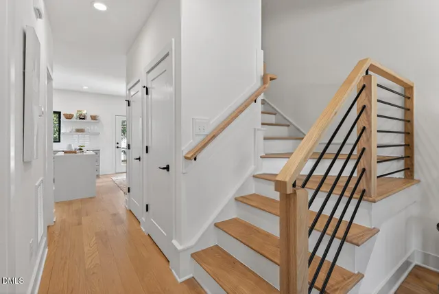 a view of a hallway with wooden floor and staircase