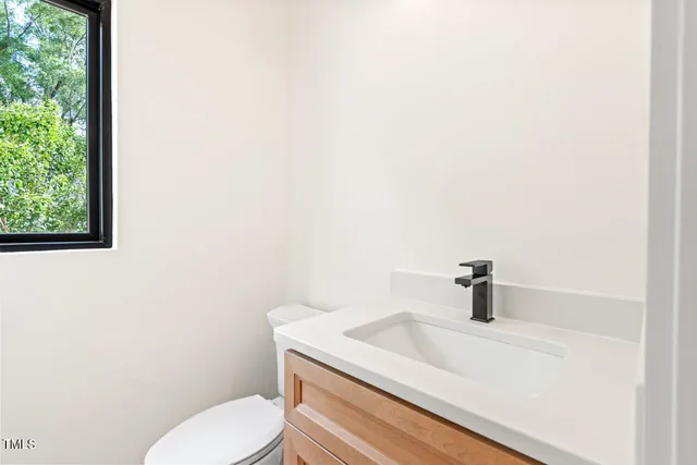 a bathroom with a sink a toilet and a window