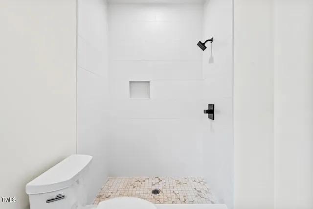 a bathroom with a toilet and a shower