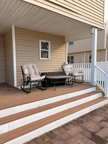 a view of a patio with table and chairs with wooden floor and fence