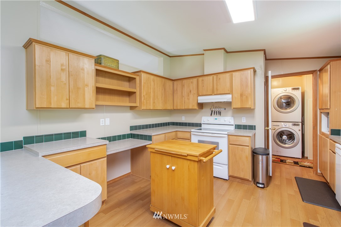9134 176th Avenue Southwest Rochester, WA 98579 - Photo 11 of 24 a kitchen with stainless steel appliances granite countertop a sink a stove a refrigerator with cabinets and wooden floor
