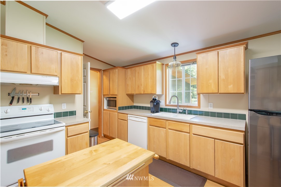 9134 176th Avenue Southwest Rochester, WA 98579 - Photo 12 of 24 a kitchen with a stove a sink and a refrigerator