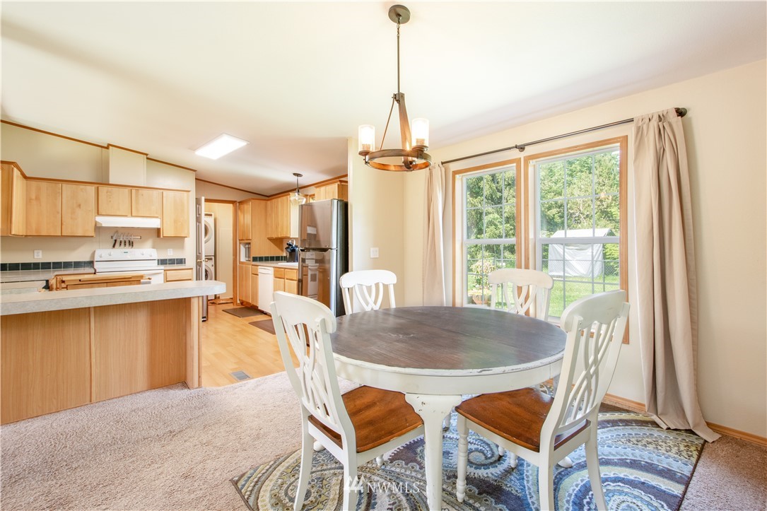 9134 176th Avenue Southwest Rochester, WA 98579 - Photo 13 of 24 a dining room with furniture a chandelier and wooden floor
