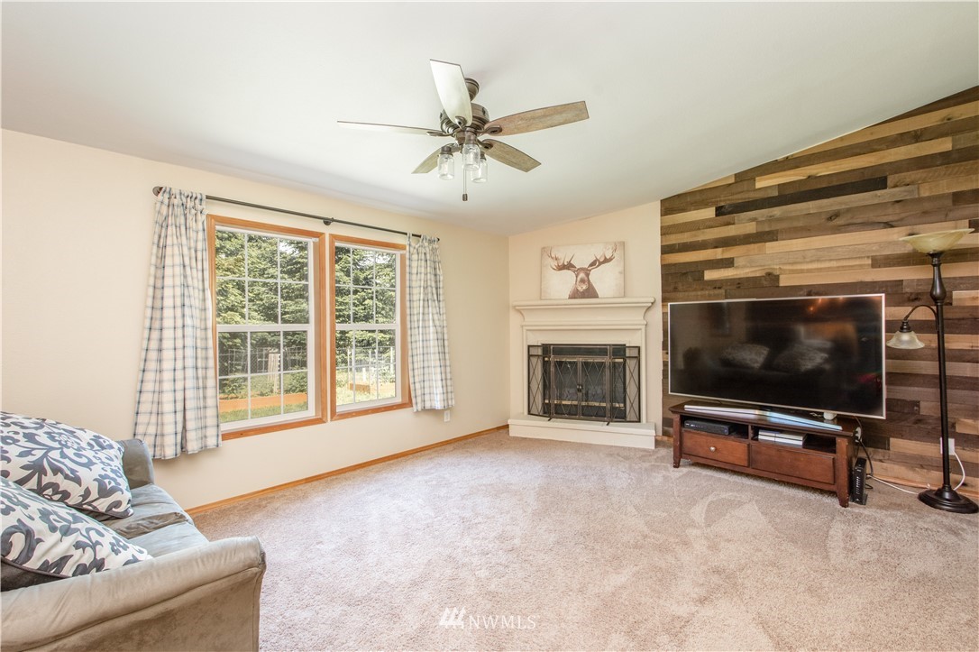 9134 176th Avenue Southwest Rochester, WA 98579 - Photo 15 of 24 a living room with furniture a flat screen tv and a fireplace