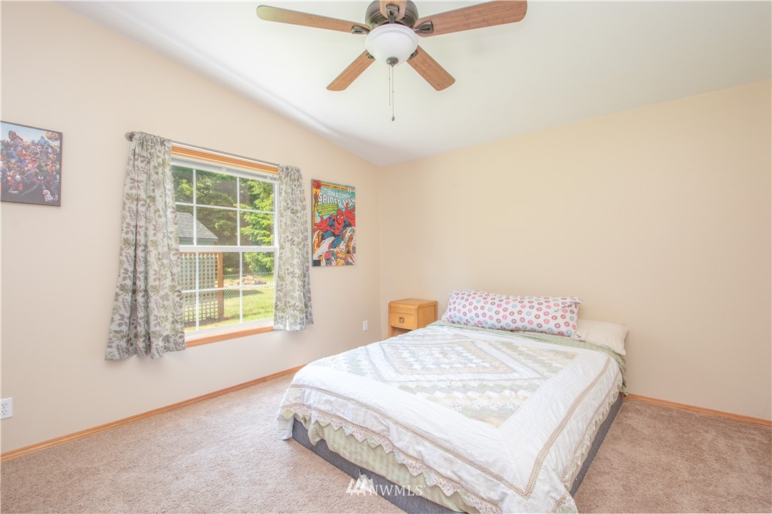 9134 176th Avenue Southwest Rochester, WA 98579 - Photo 21 of 24 a bedroom with a bed and a chandelier