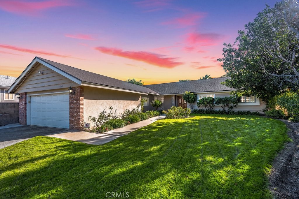 a view of a house with a big yard and large tree