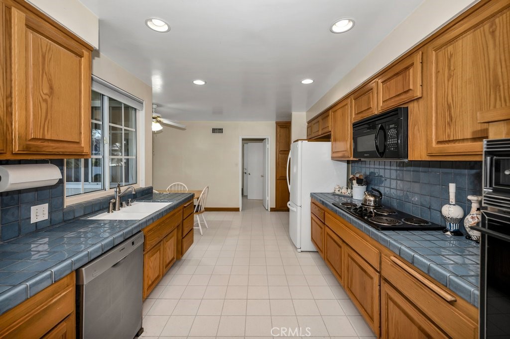 9916 Bothwell Road Northridge, CA 91324 - Photo 15 of 41 a large kitchen with granite countertop a sink and a stove top oven