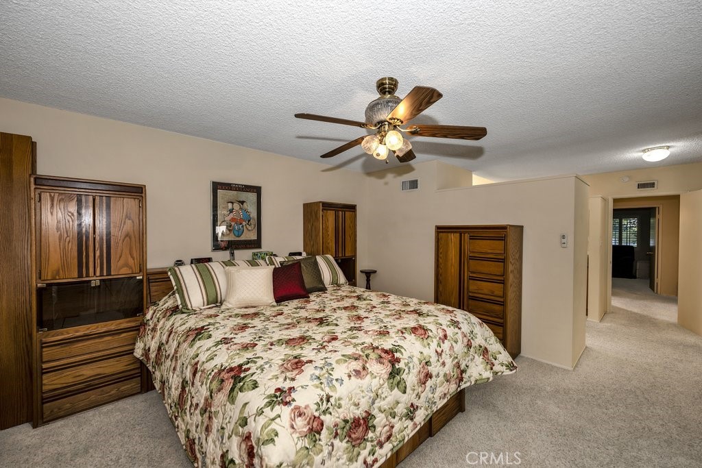 9916 Bothwell Road Northridge, CA 91324 - Photo 23 of 41 a bedroom with a large bed and a chandelier