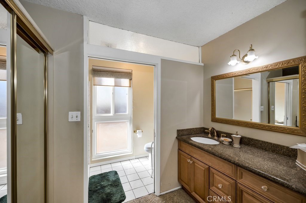 9916 Bothwell Road Northridge, CA 91324 - Photo 28 of 41 a bathroom with a granite countertop sink and a mirror