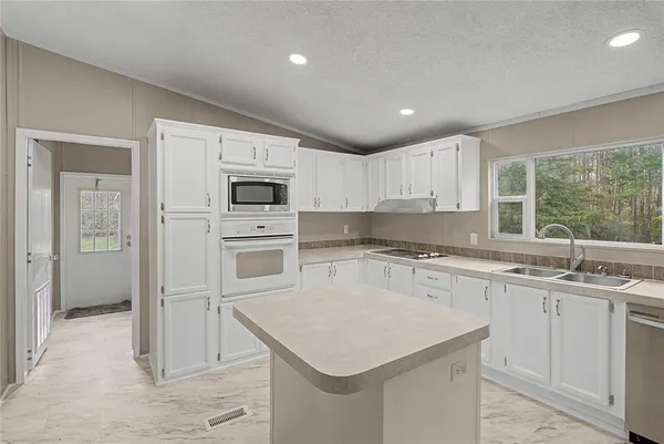 a kitchen with white cabinets and white appliances