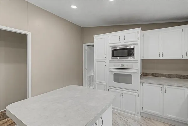 a kitchen that has a sink cabinets counter space and appliances