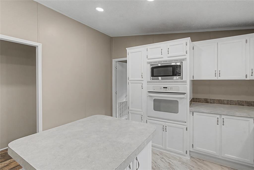 428 Cash Blackmon Road Logansport, LA 71049 - Photo 13 of 40 a kitchen with white cabinets and white appliances