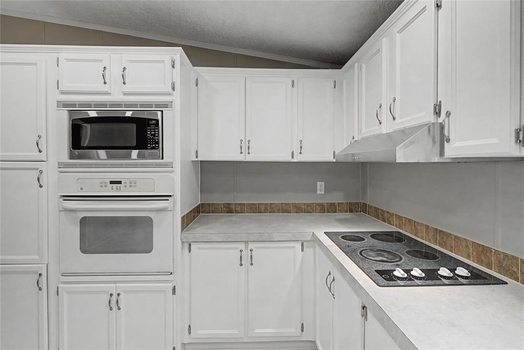 428 Cash Blackmon Road Logansport, LA 71049 - Photo 14 of 40 a kitchen with white cabinets and appliances
