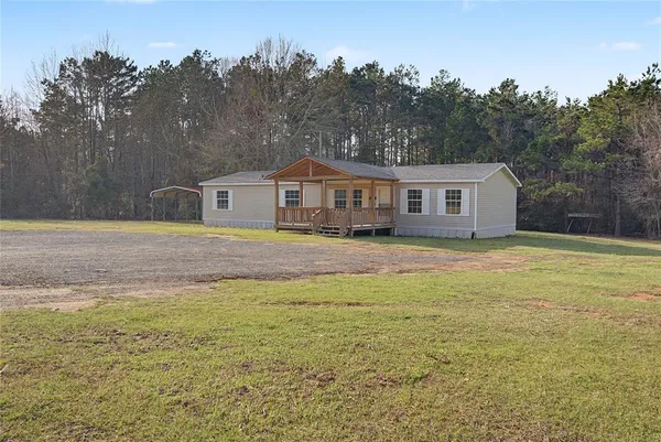 a view of a house with a backyard and a garden