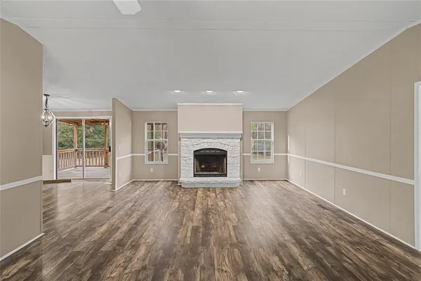 a view of a livingroom with wooden floor and a fireplace