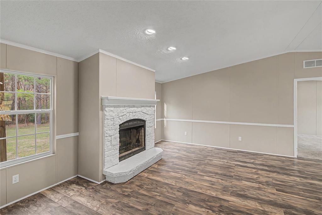 428 Cash Blackmon Road Logansport, LA 71049 - Photo 8 of 40 a view of a livingroom with wooden floor and a fireplace