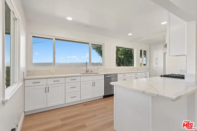 a kitchen with granite countertop white cabinets and white appliances
