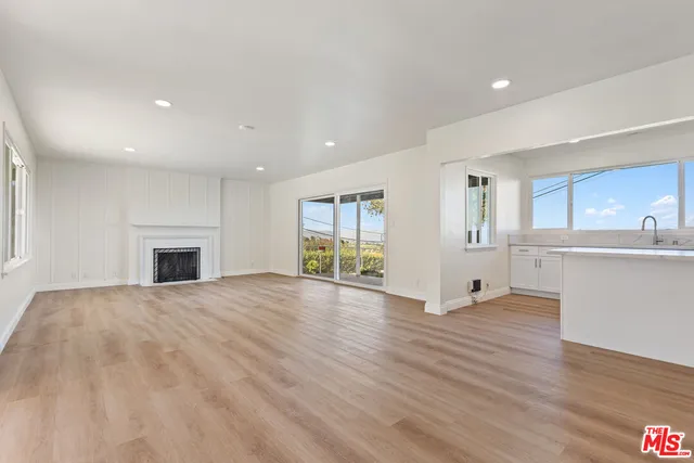 a view of an empty room with a fireplace and a window