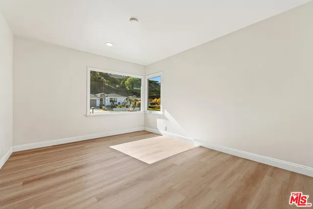 an empty room with wooden floor and window