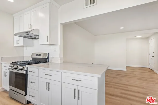 a kitchen with white cabinets and appliances