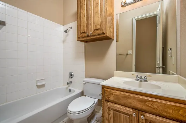a bathroom with a granite countertop sink a toilet and shower