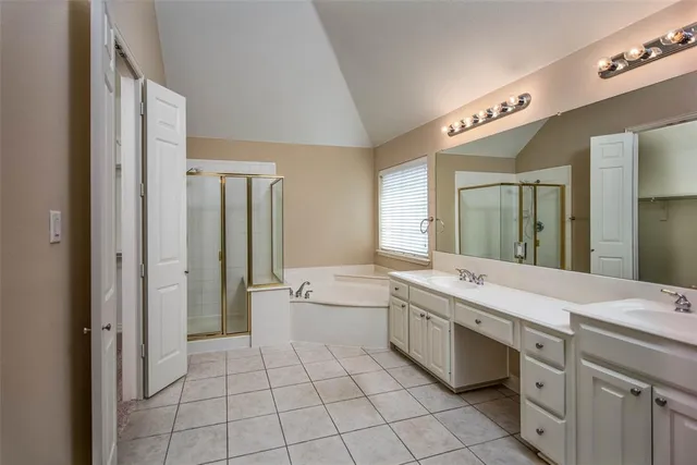 a spacious bathroom with a granite countertop sink a mirror and a bathtub