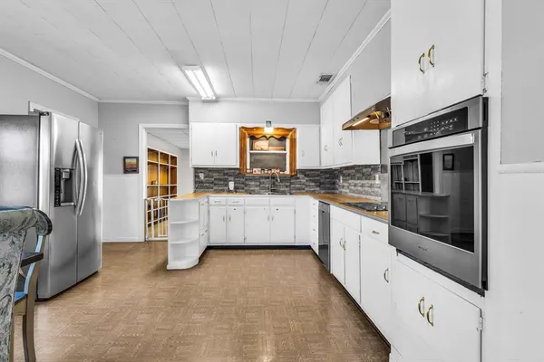 a large white kitchen with stainless steel appliances