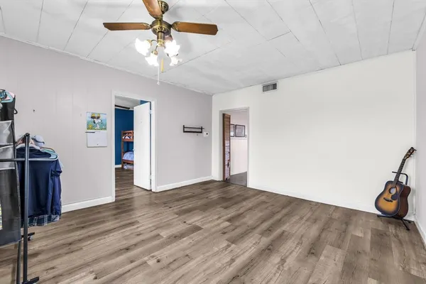 a view of a livingroom with wooden floor and a ceiling fan