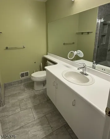 a bathroom with a toilet sink and mirror