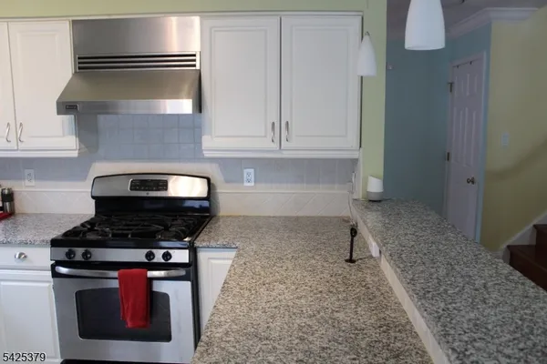 a kitchen with stainless steel appliances granite countertop a stove and a granite counter tops