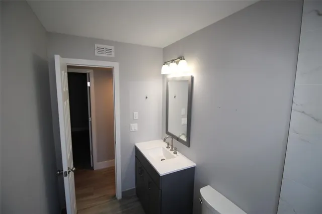 a bathroom with a sink a toilet and mirror