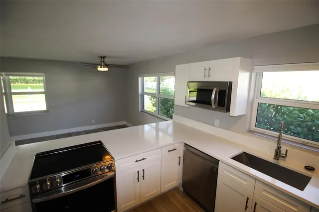 a kitchen with a sink stove and microwave