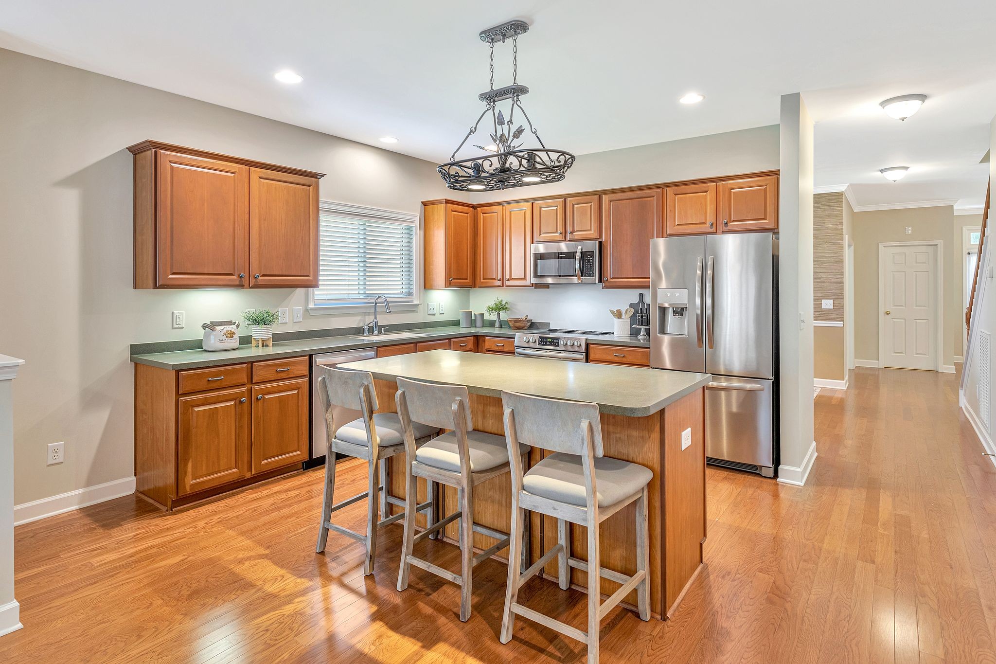 1311 Decatur Circle Franklin, TN 37067 - Photo 12 of 38 a kitchen with stainless steel appliances a dining table chairs sink and cabinets