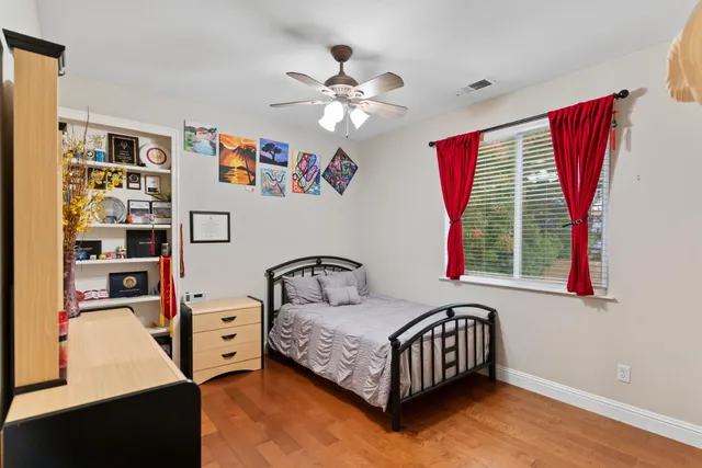 a spacious bedroom with a bed and a flat screen tv