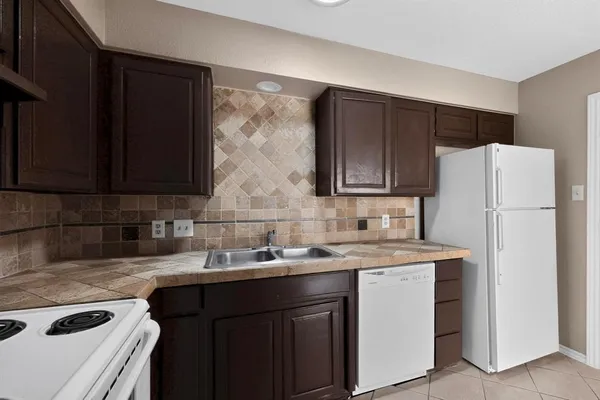 a kitchen with a sink a refrigerator and cabinets