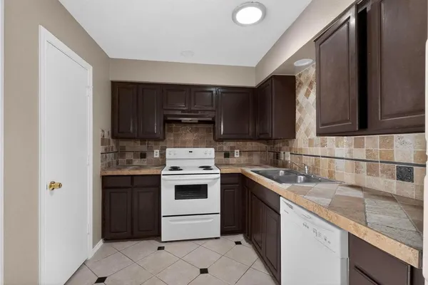 a kitchen with a sink a stove and cabinets