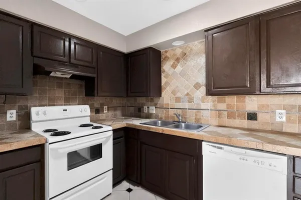 a kitchen with stainless steel appliances granite countertop a sink stove microwave refrigerator and cabinets