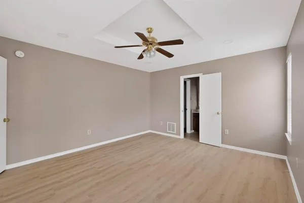 an empty room with a ceiling fan and window