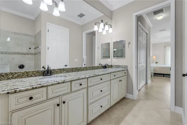 a bathroom with a granite countertop double vanity sink a mirror and a