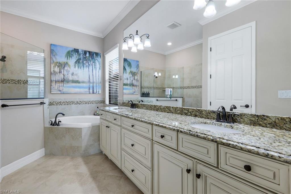 12832 Kinross Lane Naples, FL 34120 - Photo 14 of 44 a bathroom with a granite countertop bathtub a double vanity sink a vanity and a large mirror