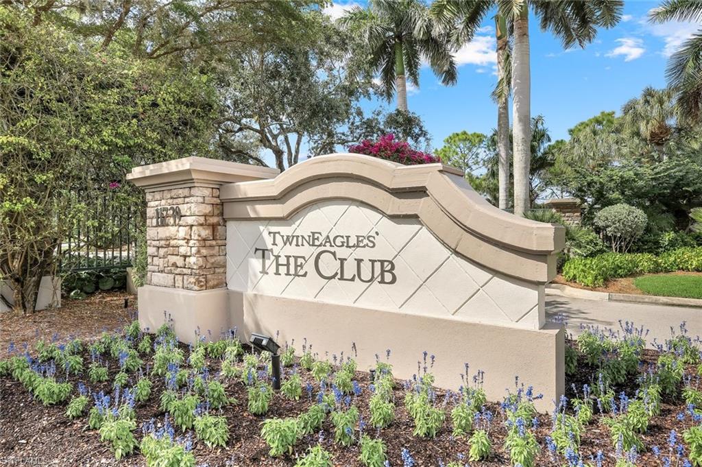 12832 Kinross Lane Naples, FL 34120 - Photo 27 of 44 a view of a sign board with flower plants and wooden fence