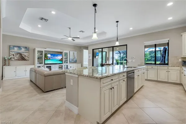 a large kitchen with kitchen island a large counter top space a sink stainless steel appliances and cabinets