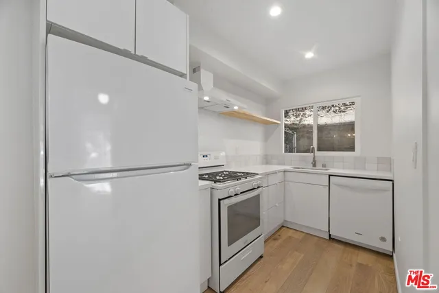 a kitchen with white cabinets and white appliances