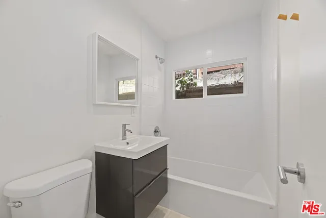 a bathroom with a sink mirror vanity and toilet
