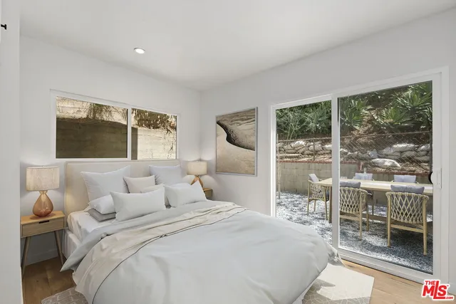 a bedroom with a large bed and a flat tv screen next to a window