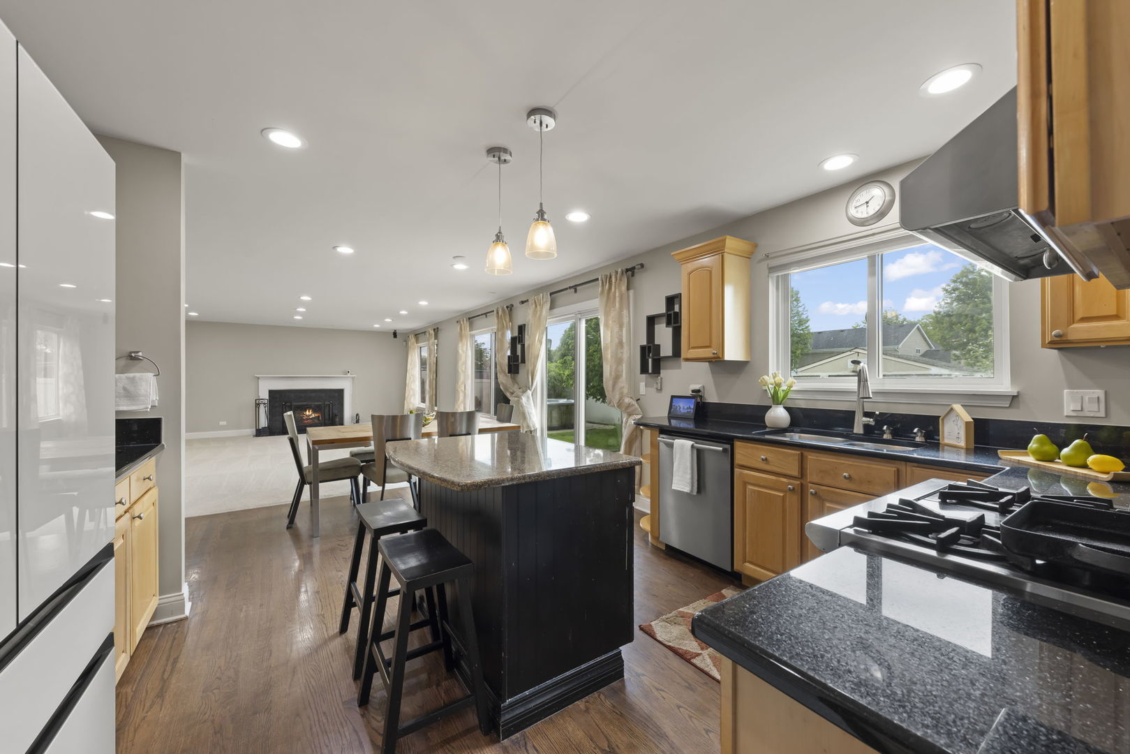 1462 Haversham Drive Aurora, IL 60502 - Photo 7 of 44 a kitchen with stainless steel appliances granite countertop a stove a refrigerator a kitchen island a stove and a dining table with wooden floor
