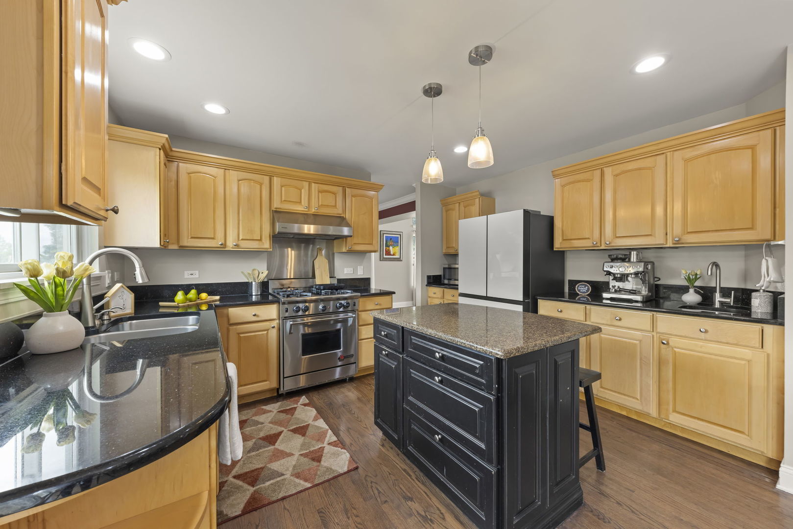 1462 Haversham Drive Aurora, IL 60502 - Photo 9 of 44 a kitchen with stainless steel appliances granite countertop a stove top oven a sink dishwasher a dining table and chairs with wooden floor